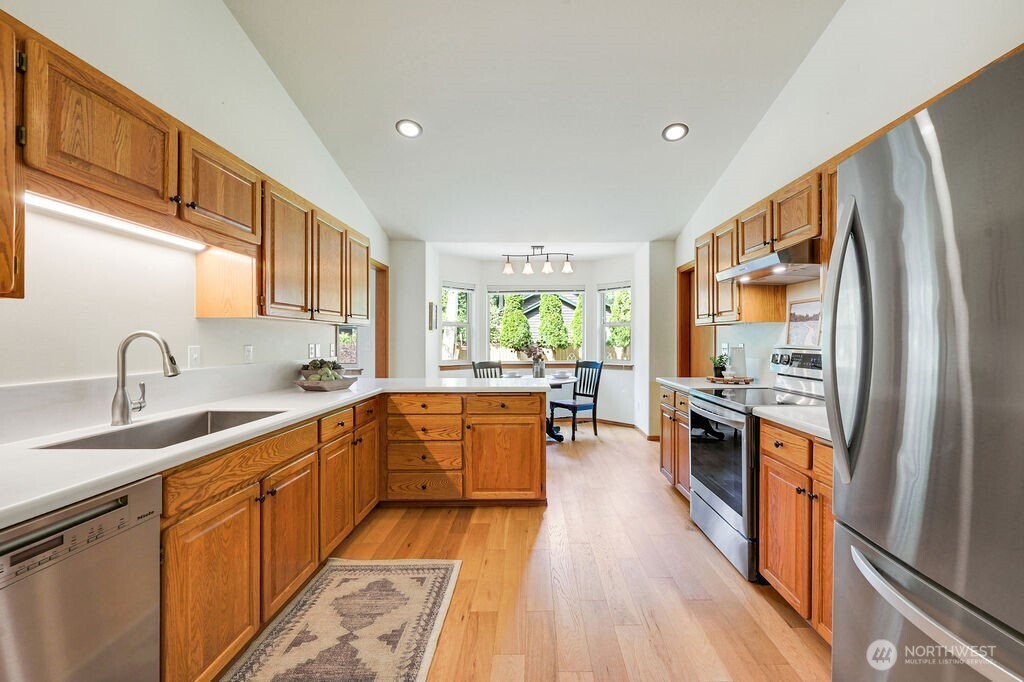 4919 Bell Street Port Townsend, WA 98368 - Photo 16 of 40 a large kitchen with stainless steel appliances granite countertop a lot of counter space and wooden floors