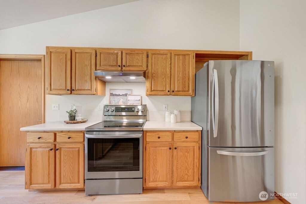4919 Bell Street Port Townsend, WA 98368 - Photo 18 of 40 a kitchen with stainless steel appliances granite countertop a refrigerator and a stove top oven