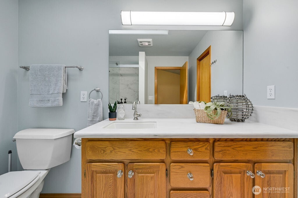 4919 Bell Street Port Townsend, WA 98368 - Photo 33 of 40 a bathroom with a granite countertop toilet sink and mirror