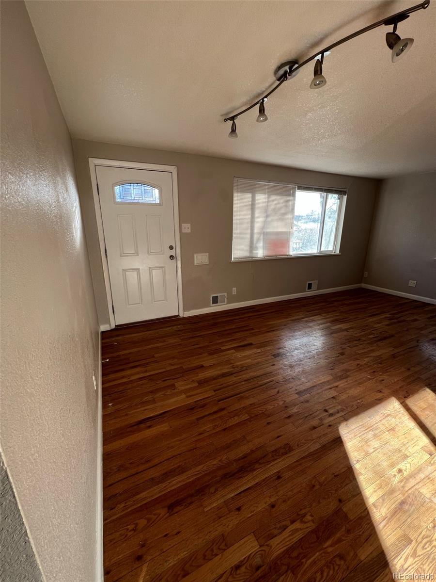 1245 Yates Street Denver, CO 80204 - Photo 2 of 24 a view of an empty room with wooden floor and a window