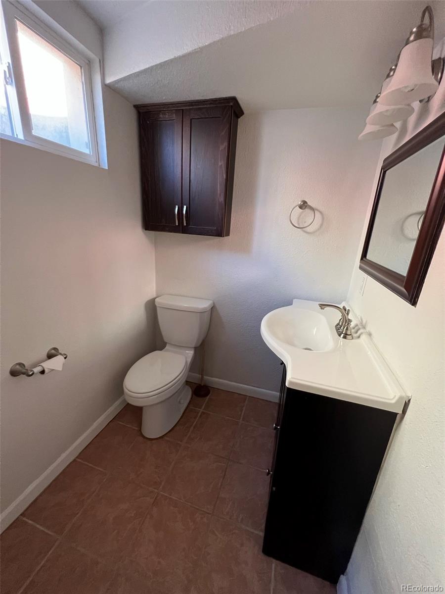 1245 Yates Street Denver, CO 80204 - Photo 21 of 24 a bathroom with a sink toilet and mirror