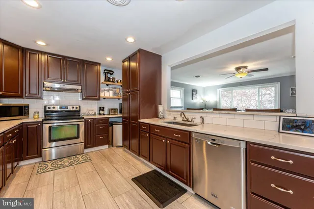 a large kitchen with stainless steel appliances granite countertop a stove and a sink