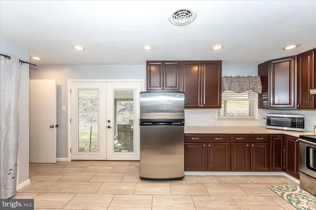 a kitchen with a sink window and refrigerator