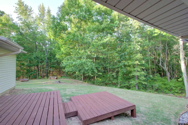 a view of a wooden deck with a yard