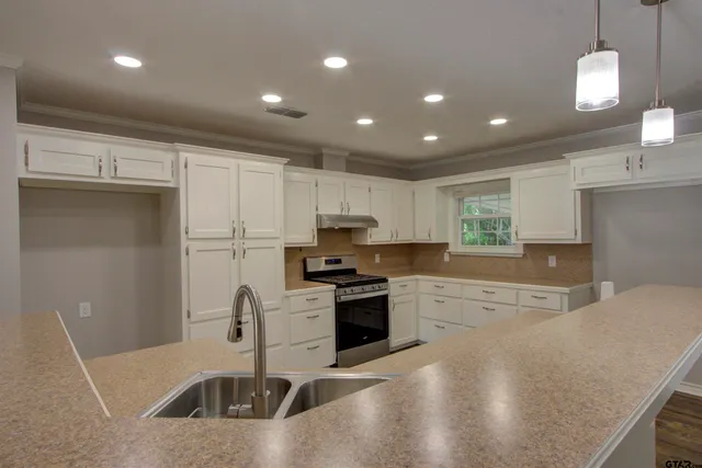 a kitchen with stainless steel appliances granite countertop a sink a stove and a refrigerator