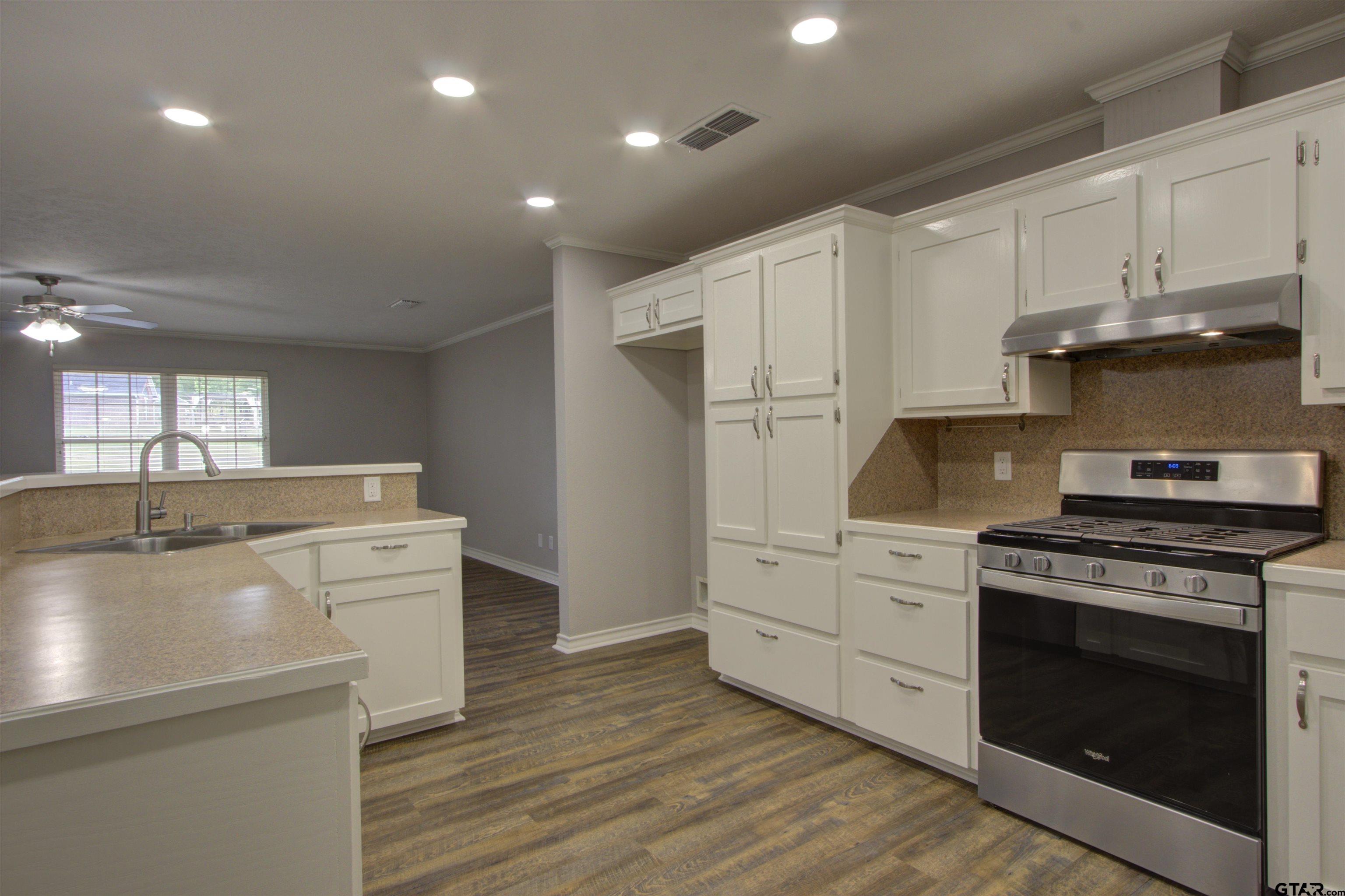 720 Tennessee Acres Drive Texarkana Ar, AR 71854 - Photo 6 of 31 a kitchen with stainless steel appliances white cabinets and wooden floors