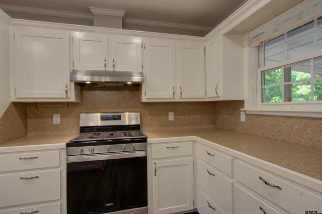 a kitchen with white cabinets and appliances