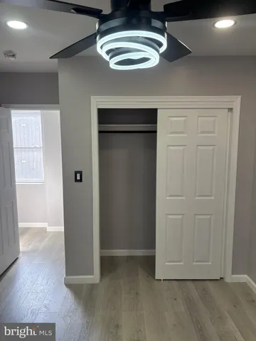 an empty room with wooden floor wooden door and windows