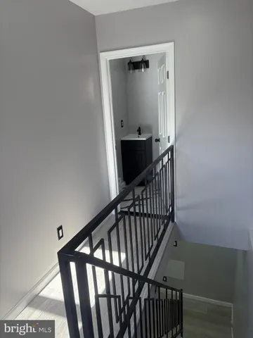 a view of staircase with railing and white walls