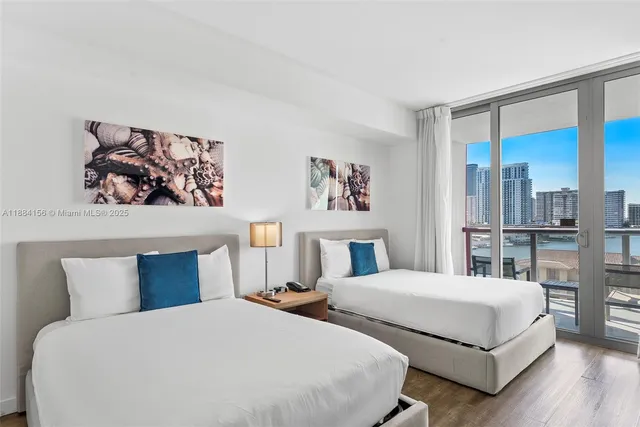 a bedroom with two beds and a painting on the wall