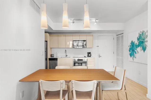 a kitchen with stainless steel appliances granite countertop a refrigerator a stove a sink a microwave oven with white cabinets