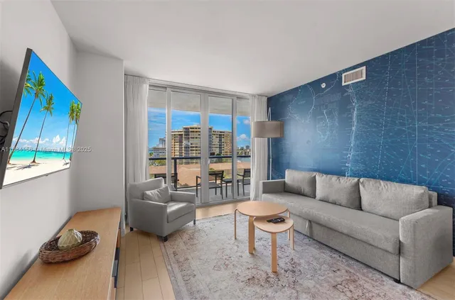 a living room with furniture and a floor to ceiling window