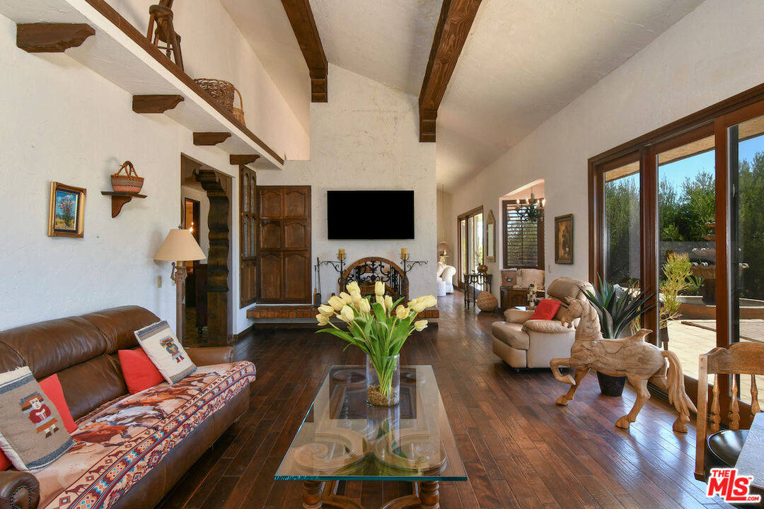 24926 Jim Bridger Road Hidden Hills, CA 91302 - Photo 8 of 28 a living room with furniture and a flat screen tv