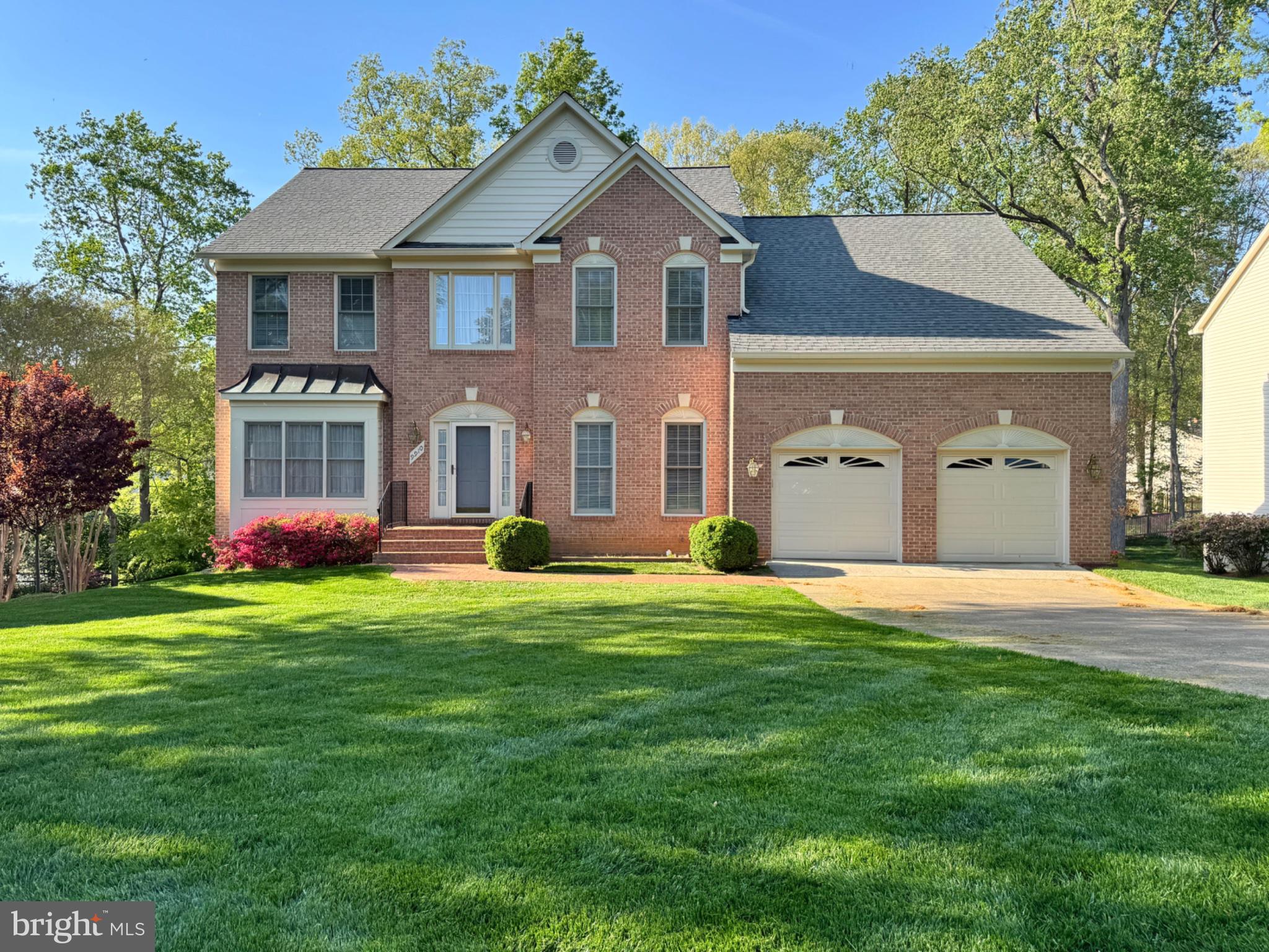 Charming brick home with lush greenery.