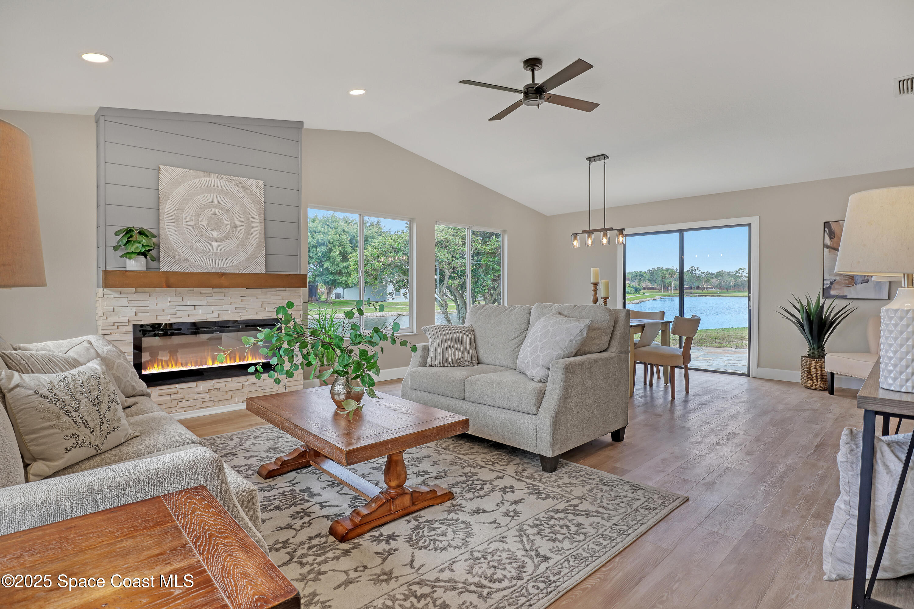 443 Myrtlewood Road Melbourne, FL 32940 - Photo 12 of 72 a living room with furniture a chandelier and a table