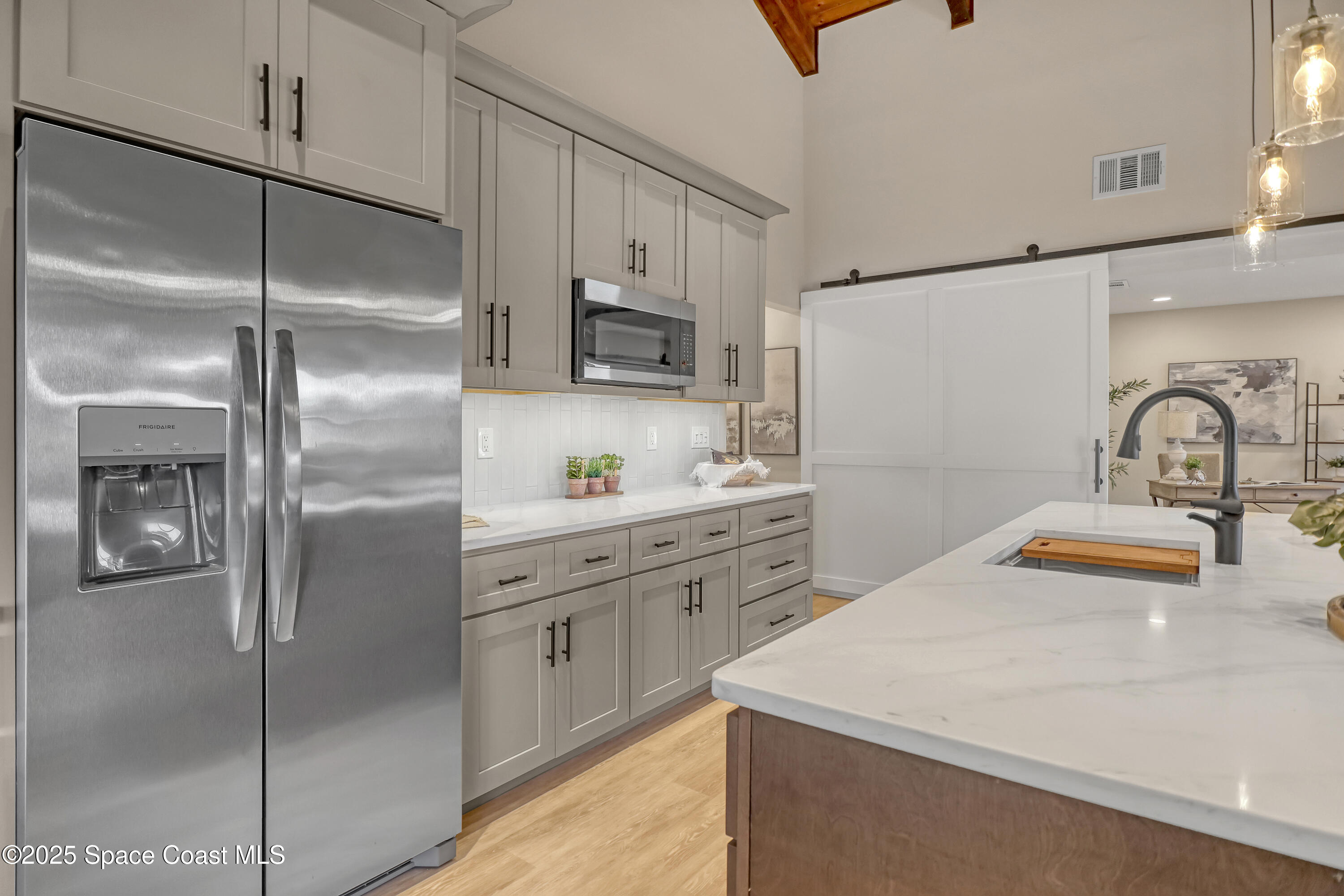 443 Myrtlewood Road Melbourne, FL 32940 - Photo 27 of 72 a kitchen with stainless steel appliances a refrigerator sink and microwave
