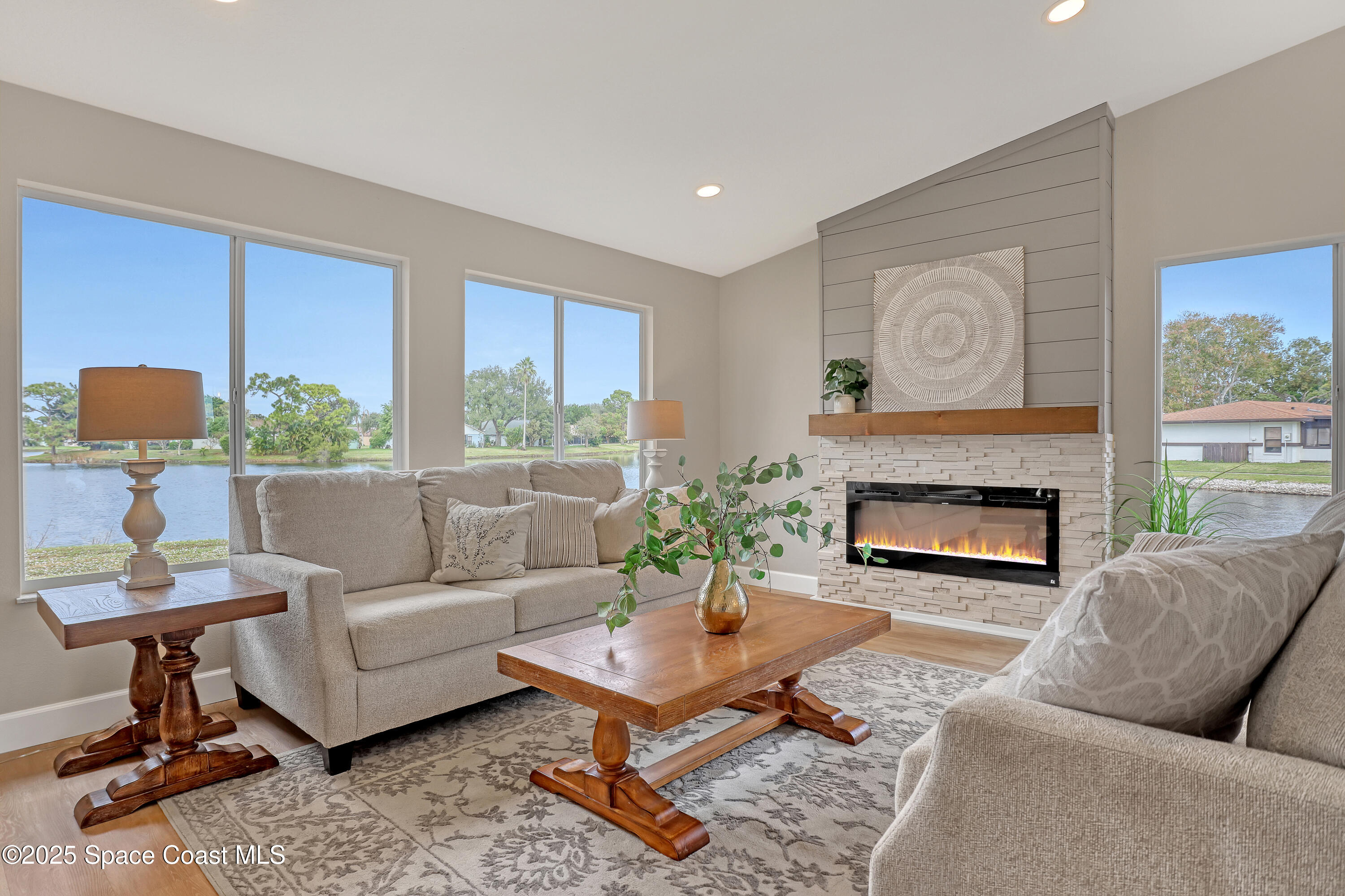 443 Myrtlewood Road Melbourne, FL 32940 - Photo 3 of 72 a living room with furniture a fireplace and a large window