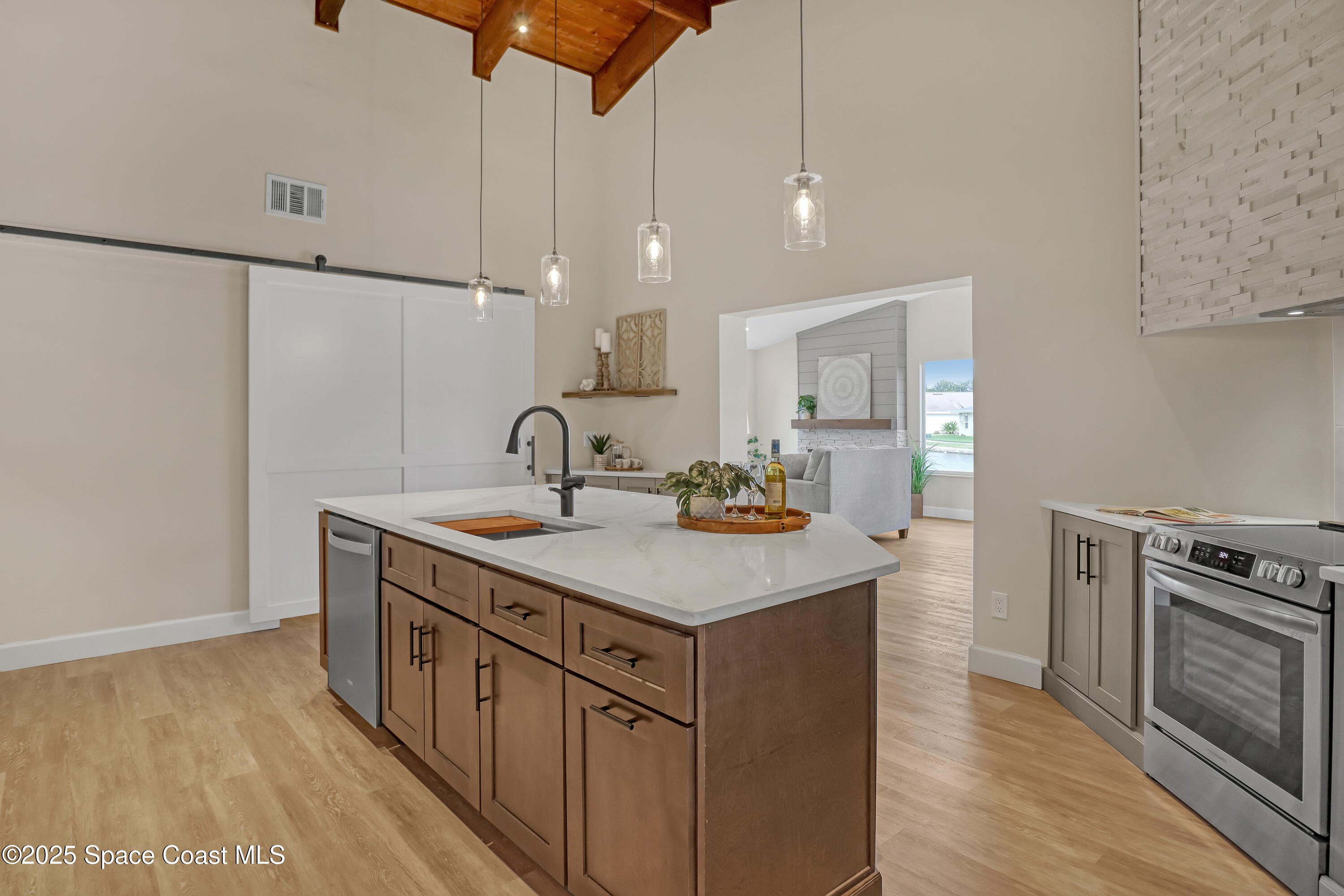 443 Myrtlewood Road Melbourne, FL 32940 - Photo 33 of 72 a kitchen with a sink a stove cabinets and wooden floor