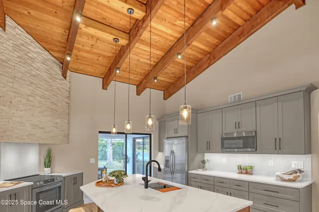 a kitchen with stainless steel appliances granite countertop a sink a stove and cabinets