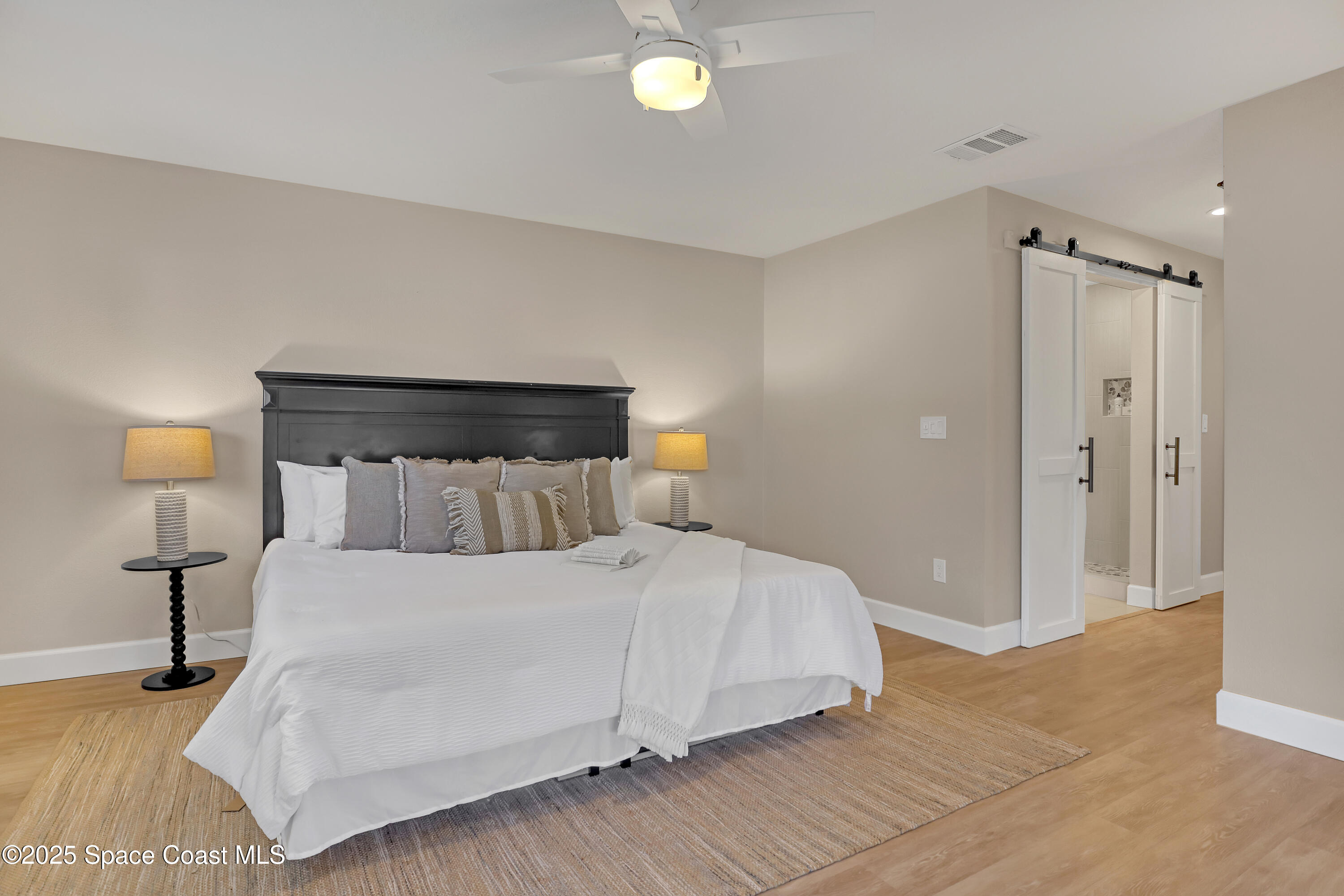 443 Myrtlewood Road Melbourne, FL 32940 - Photo 45 of 72 a bedroom with a beds and a lamp