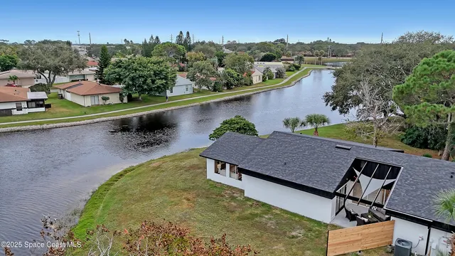an aerial view of a house with a yard and lake view