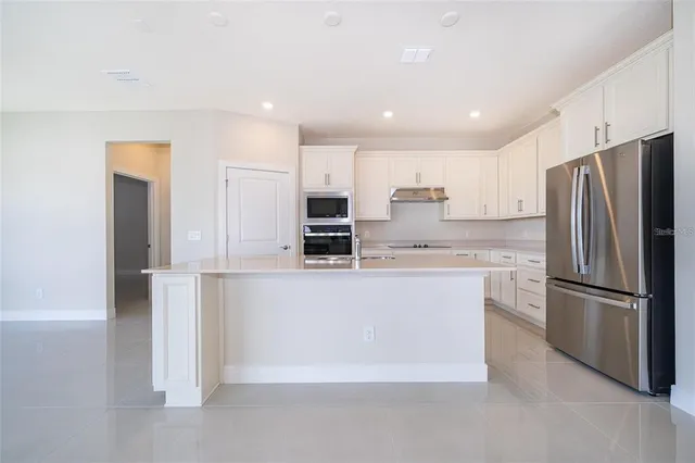 a kitchen with stainless steel appliances granite countertop a refrigerator and a stove top oven
