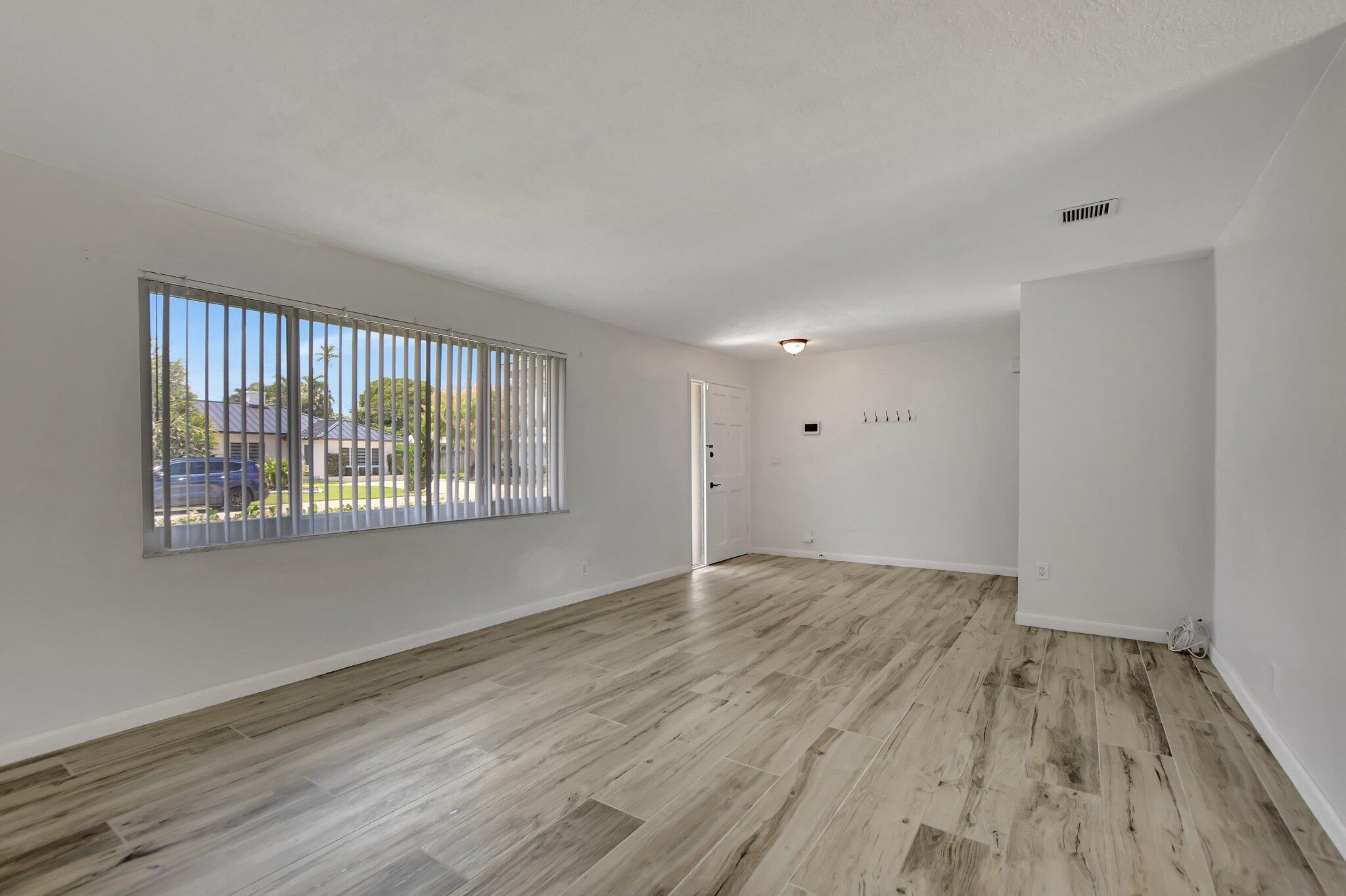 254 Northwest 11th Avenue Boca Raton, FL 33486 - Photo 12 of 66 a view of an empty room with wooden floor and a window