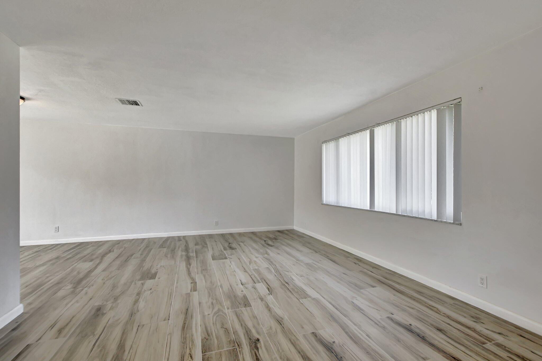 254 Northwest 11th Avenue Boca Raton, FL 33486 - Photo 13 of 66 a view of an empty room with wooden floor and a window