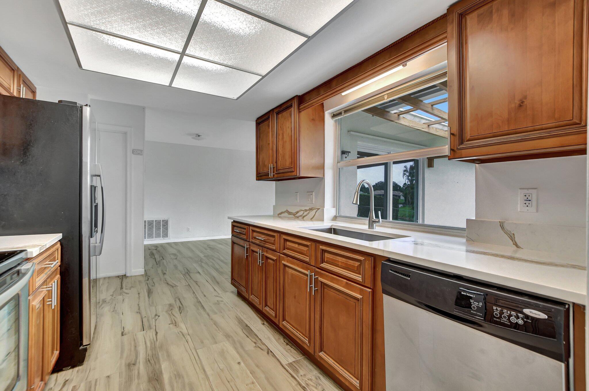 254 Northwest 11th Avenue Boca Raton, FL 33486 - Photo 19 of 66 a kitchen with stainless steel appliances granite countertop a sink stove and wooden floor