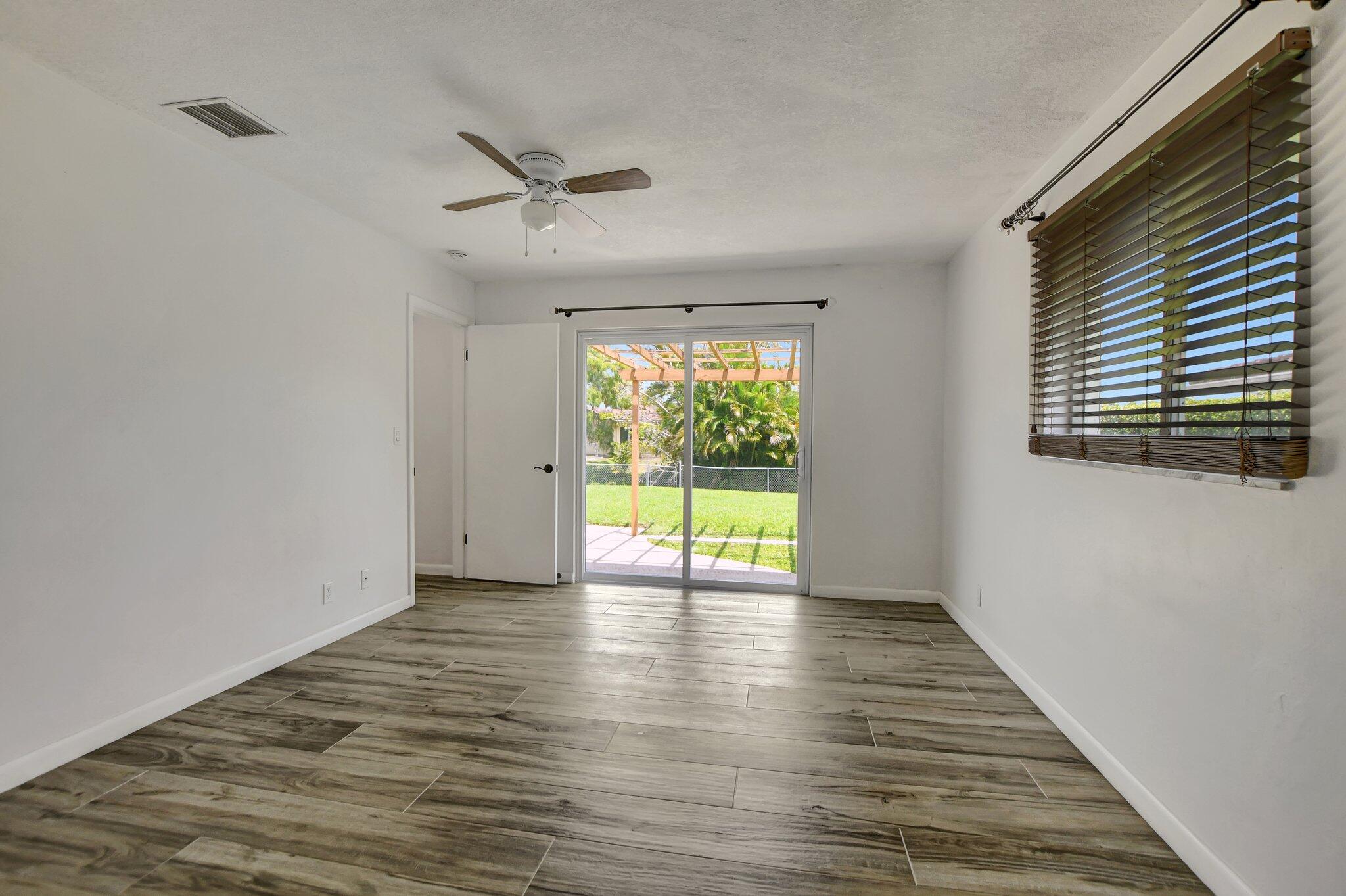 254 Northwest 11th Avenue Boca Raton, FL 33486 - Photo 28 of 66 a view of an empty room with wooden floor and a window