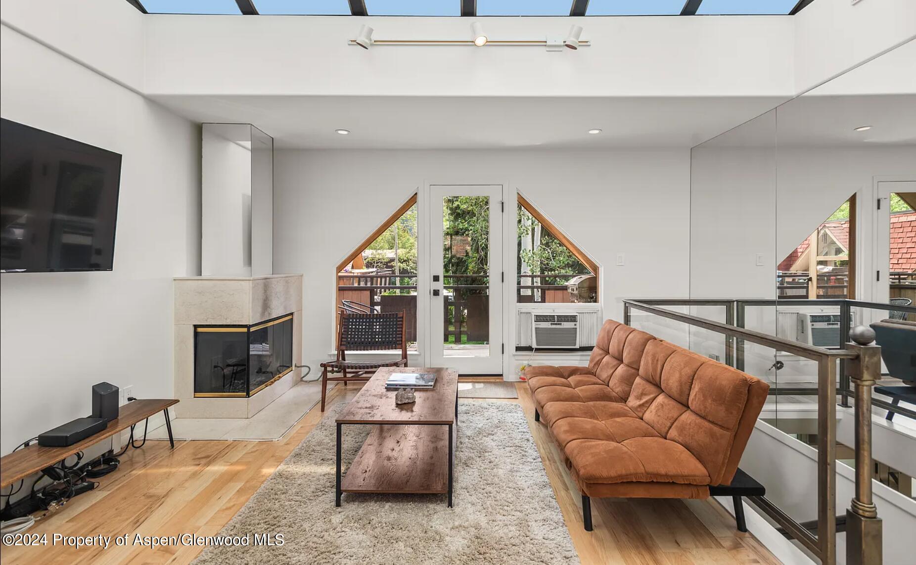 108 West Hyman Avenue, Unit 2 Aspen, CO 81611 - Photo 6 of 18 a living room with furniture a fireplace and a flat screen tv