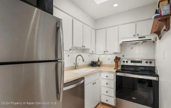 a kitchen with a white cabinets and white appliances
