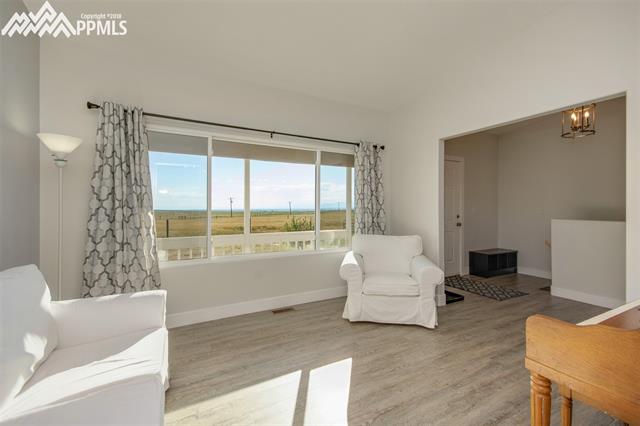This view of the formal dining room (sitting room) offers another view of the plains, the beauty of this open space and the front (main) entrance into the home. You will notice updated lighting and plumbing fixtures throughout the home. 