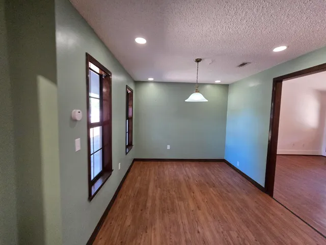 an empty room with wooden floor and staircase