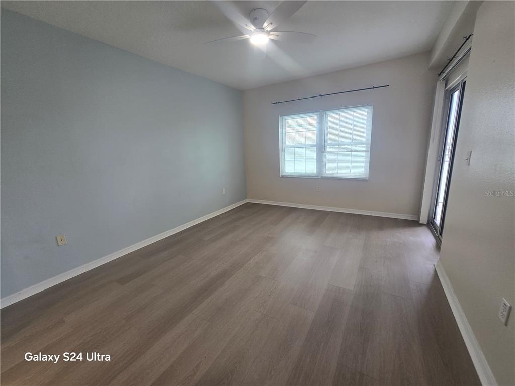 399 150th Avenue, Unit 218 Madeira Beach, FL 33708 - Photo 40 of 84 an empty room with wooden floor and windows