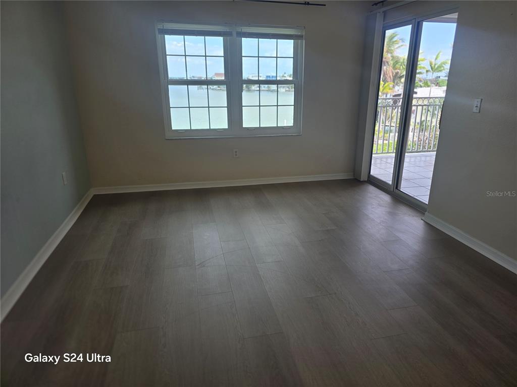 399 150th Avenue, Unit 218 Madeira Beach, FL 33708 - Photo 44 of 84 an empty room with wooden floor and windows