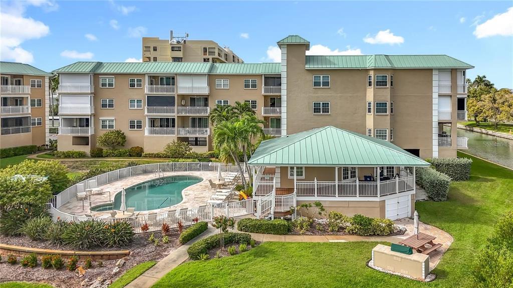 399 150th Avenue, Unit 218 Madeira Beach, FL 33708 - Photo 70 of 84 a front view of a house with swimming pool and yard