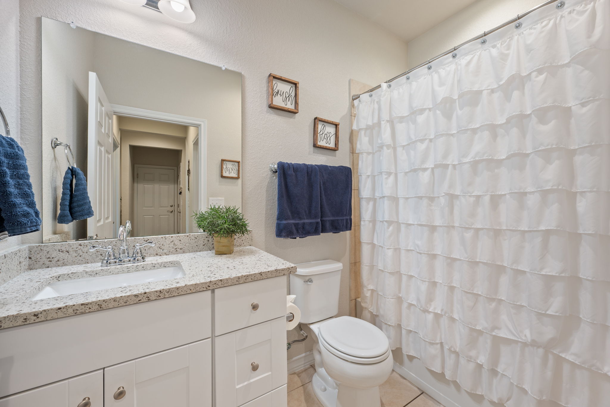 409 Limestone Road Liberty Hill, TX 78642 - Photo 20 of 35 a bathroom with a granite countertop sink mirror vanity and toilet