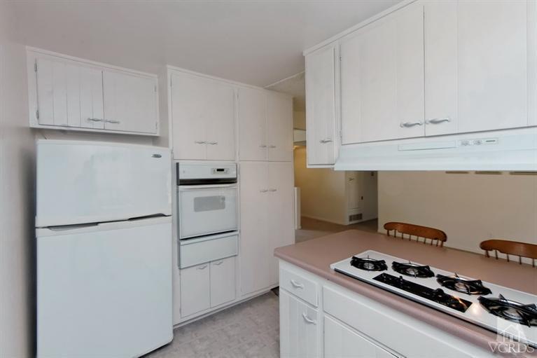 4553 Alpine Street Simi Valley, CA 93063 - Photo 6 of 25 a kitchen with white cabinets and white appliances