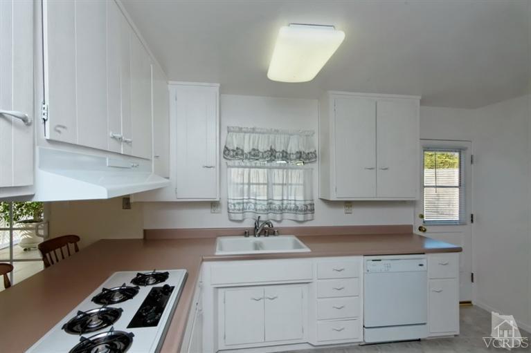 4553 Alpine Street Simi Valley, CA 93063 - Photo 7 of 25 a kitchen with granite countertop a sink a stove and cabinets