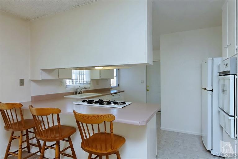 4553 Alpine Street Simi Valley, CA 93063 - Photo 8 of 25 a kitchen with granite countertop a sink a stove and a refrigerator