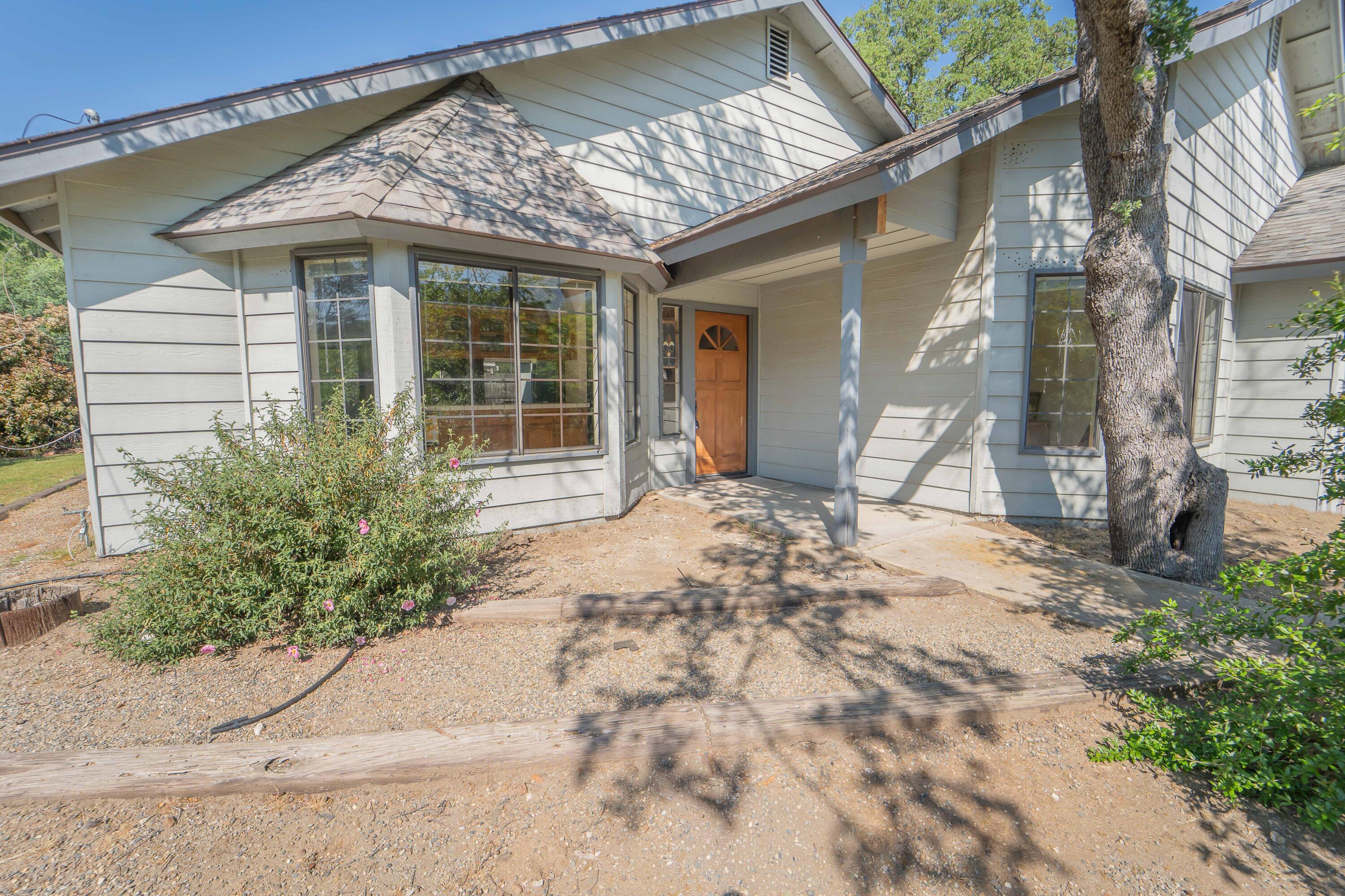 40962 Oak Ridge Drive Three Rivers, CA 93271 - Photo 1 of 36 a front view of a house with a garden and pathway