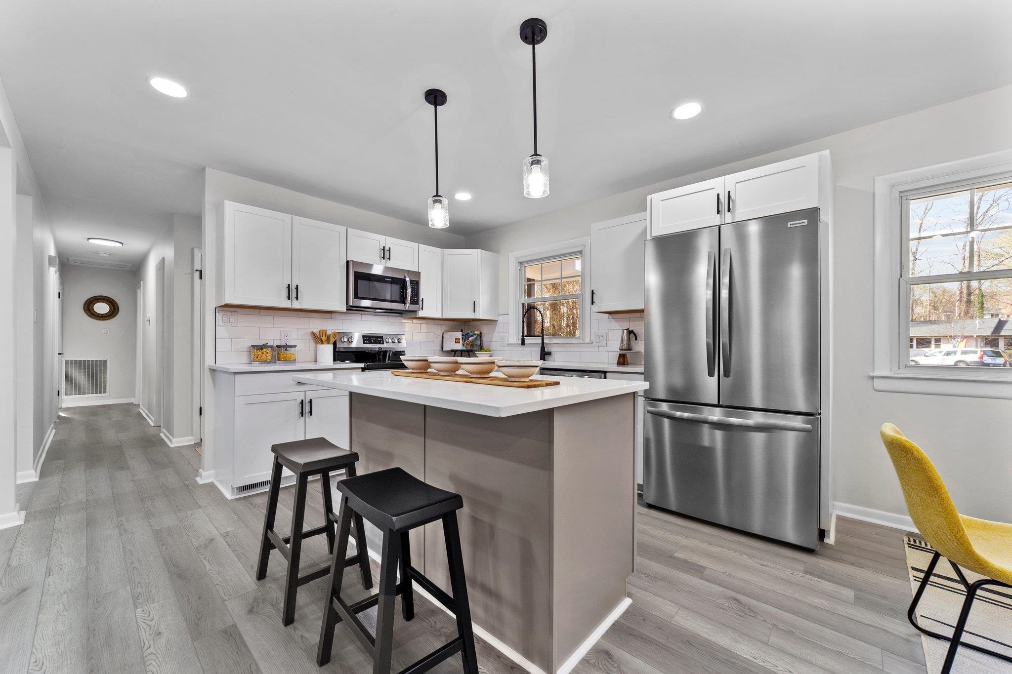 317 Wayne Circle Durham, NC 27707 - Photo 15 of 37 a kitchen with stainless steel appliances granite countertop a refrigerator a stove a sink a dining table and chairs with wooden floor