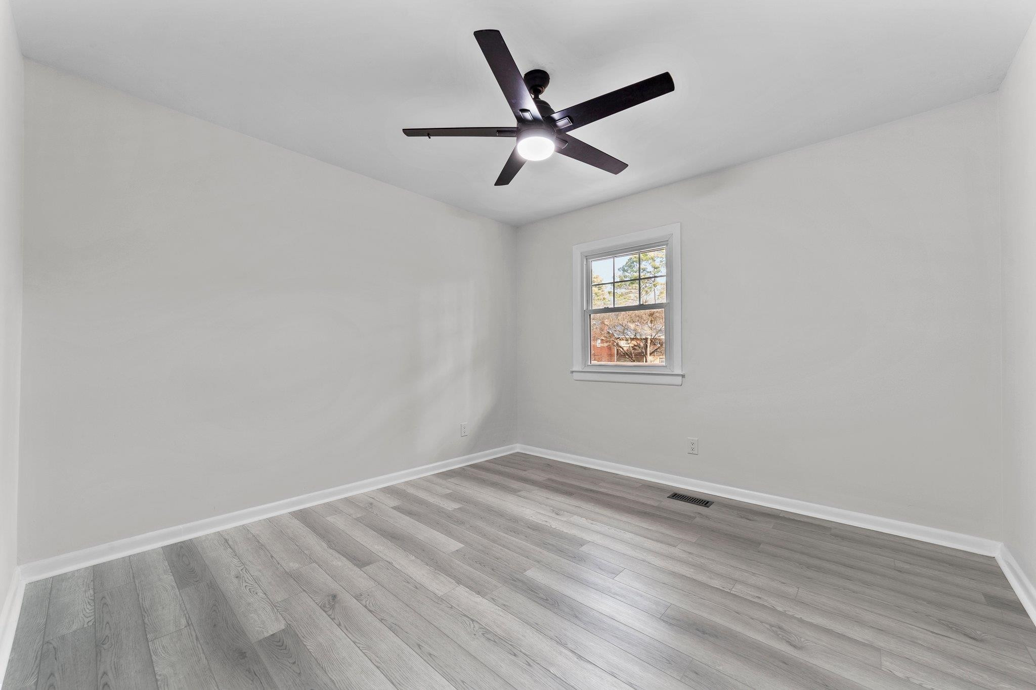 317 Wayne Circle Durham, NC 27707 - Photo 22 of 37 an empty room with wooden floor ceiling fan and windows