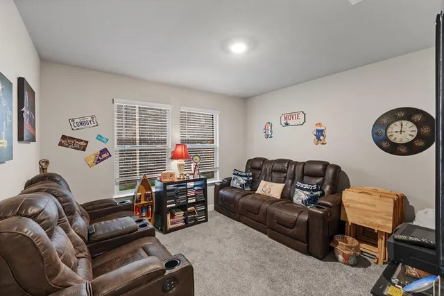 a living room with furniture a window and a flat screen tv