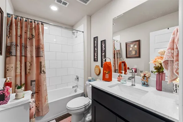 a bathroom with a sink a toilet and shower curtain