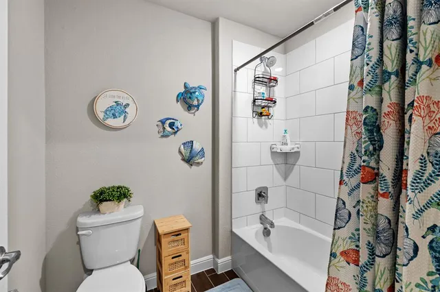 a white toilet sitting next to a bathroom sink and tub