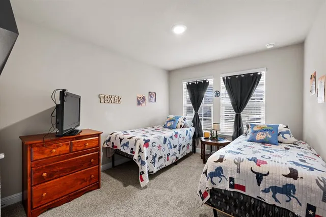 a bedroom with two beds and a dresser