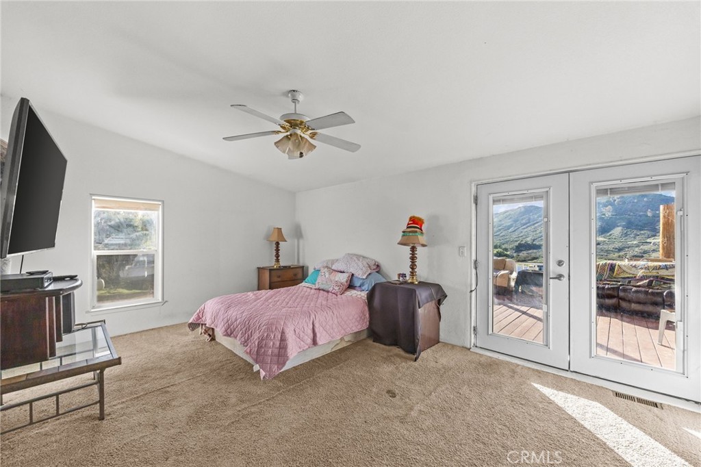 29825 Porth Road Murrieta, CA 92563 - Photo 23 of 40 a bedroom with a bed flat screen tv and a large window
