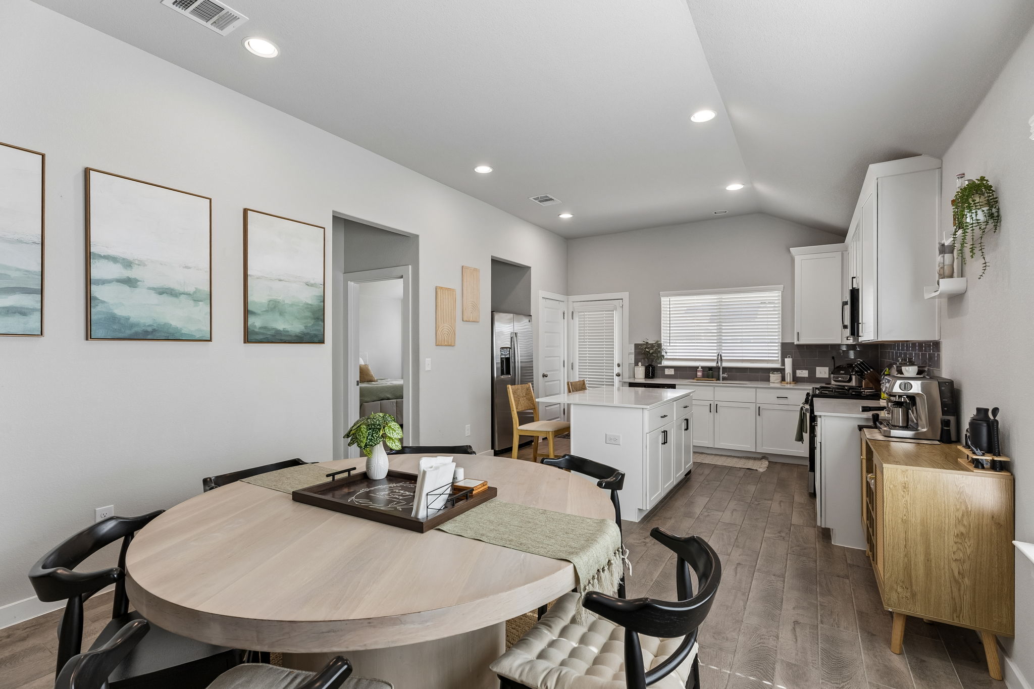 164 Appleberry Lane Elgin, TX 78621 - Photo 6 of 40 Vaulted ceilings and wood-style flooring enhance this open-concept kitchen and dining area.